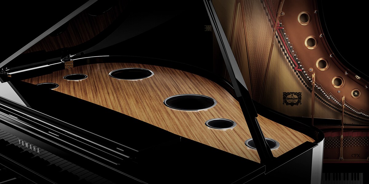 صورة مركّبة تُظهر مكبّرات الصوت في ياماها كلافينوفا CLP-895GP عن قرب وبيانو ياماها CFX