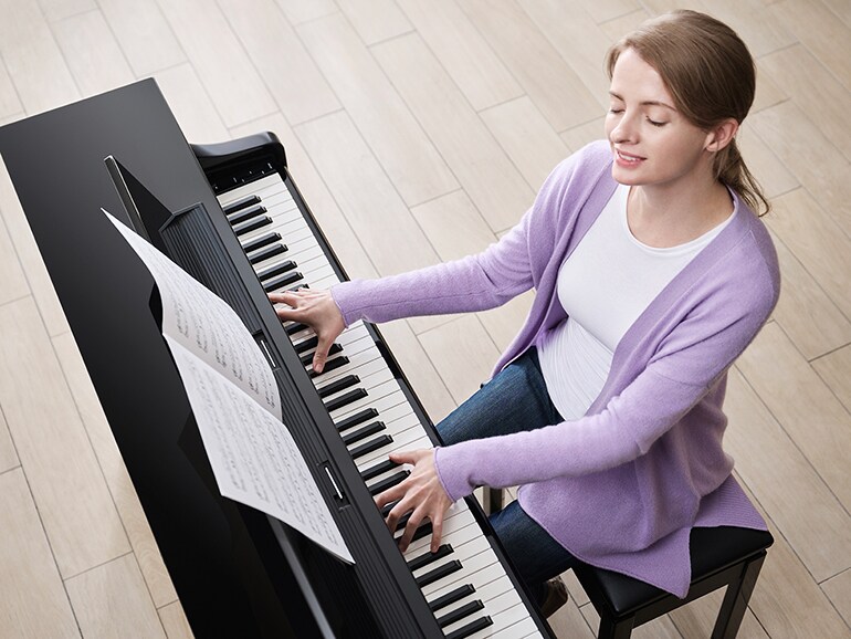 صورة شخص يعزف بسرور على بيانو  Clavinova CLP-875PE