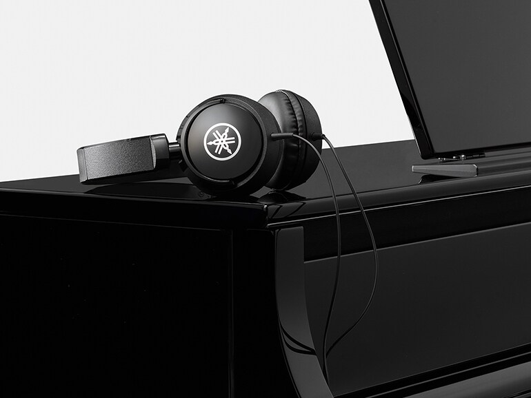 ياماها كلافينوفا CLP-875PE مع سماعات رأس موضوعة على سطحه