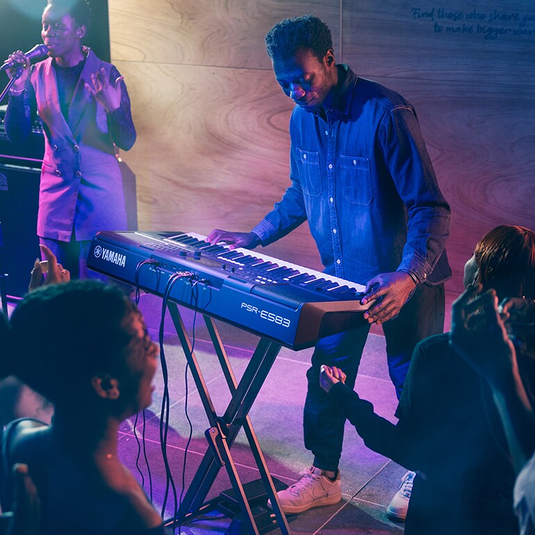 A person playing Yamaha Portable Keyboard PSR-E583 on the stage